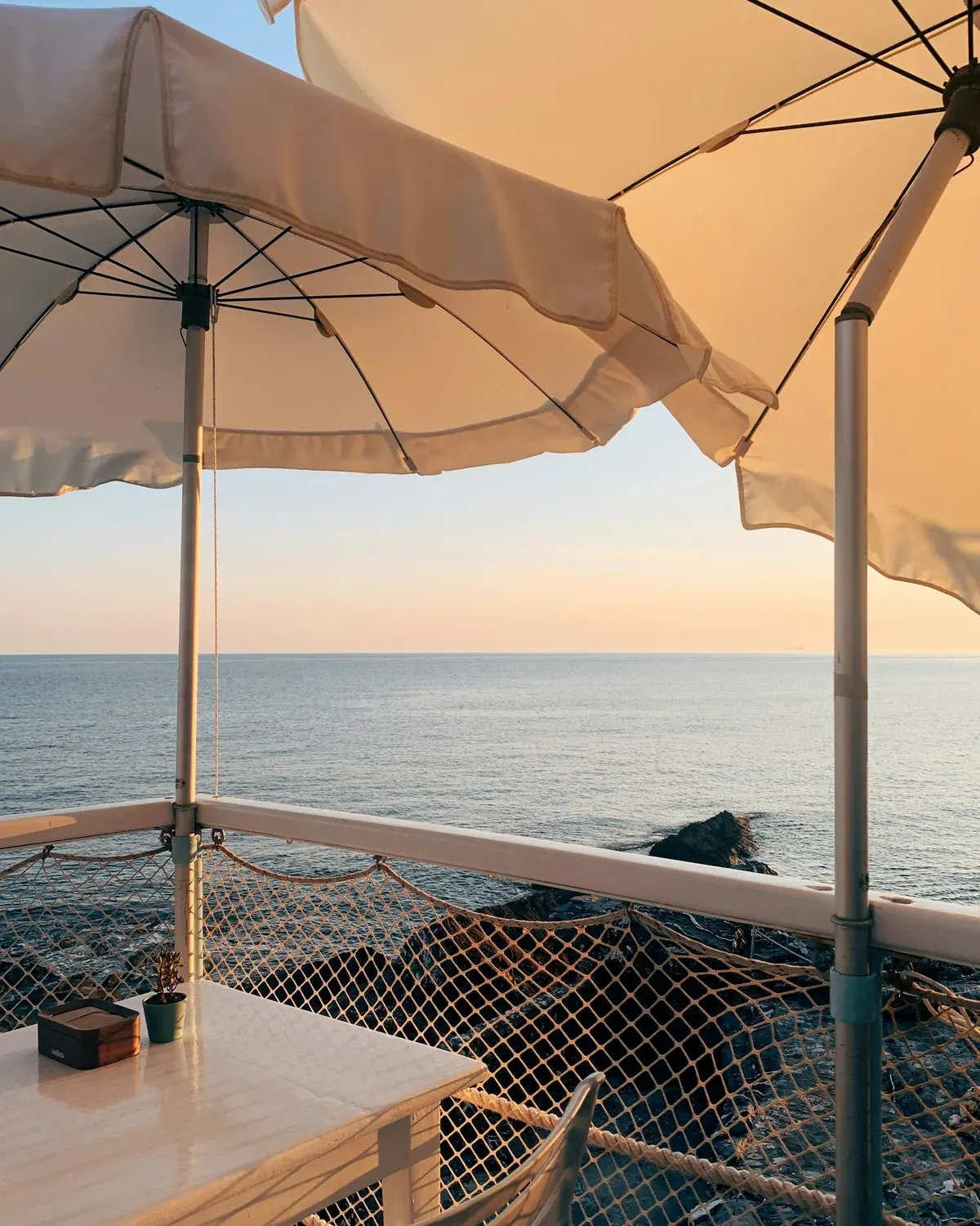 Terrasse ombragée face à la mer à l'heure dorée